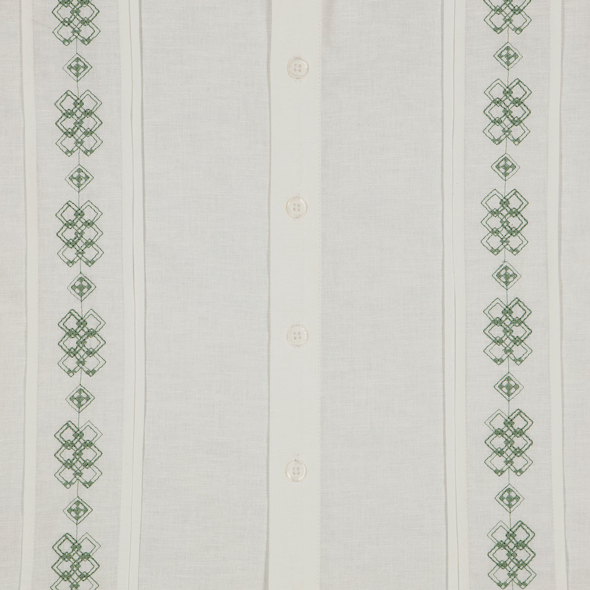 Detalle de camisa guayabera blanca con bordado verde.