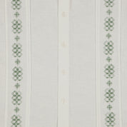 Detalle de camisa guayabera blanca con bordado verde.