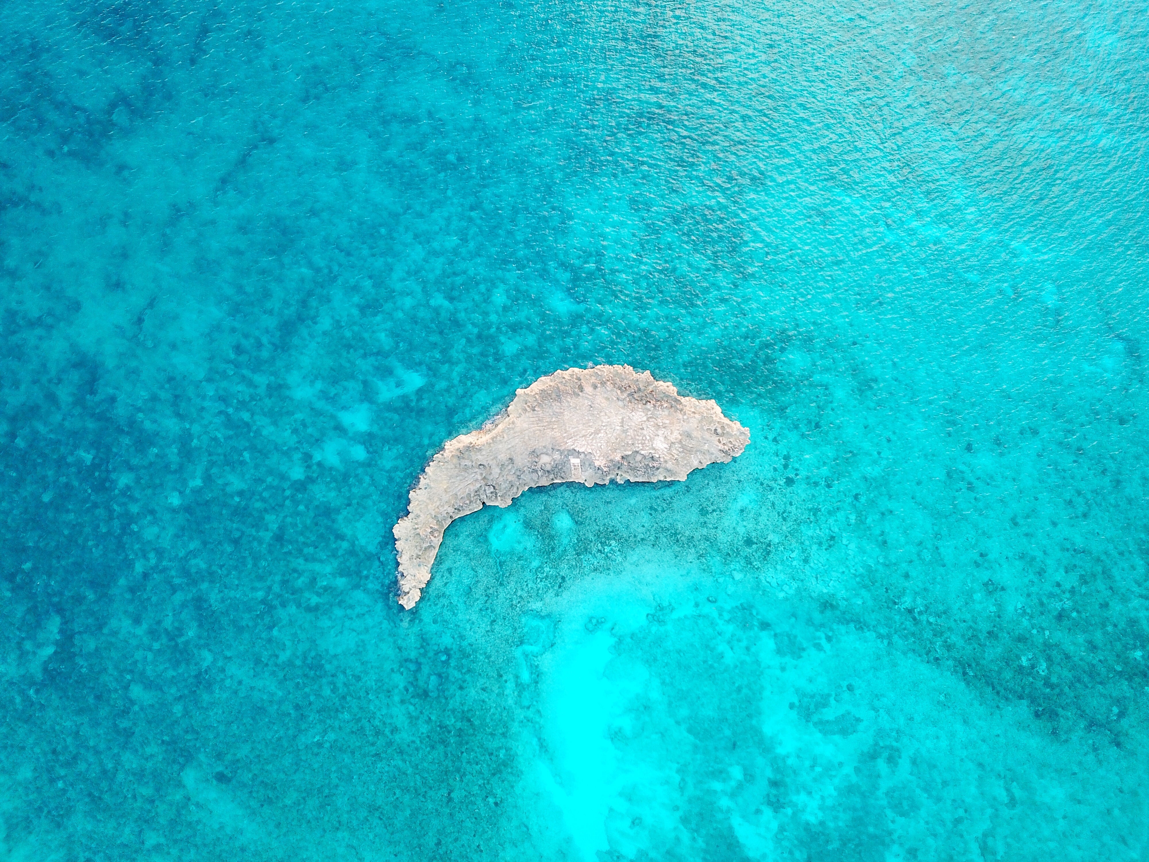 small-rocky-island-in-blue-ocean-shallows.jpg
